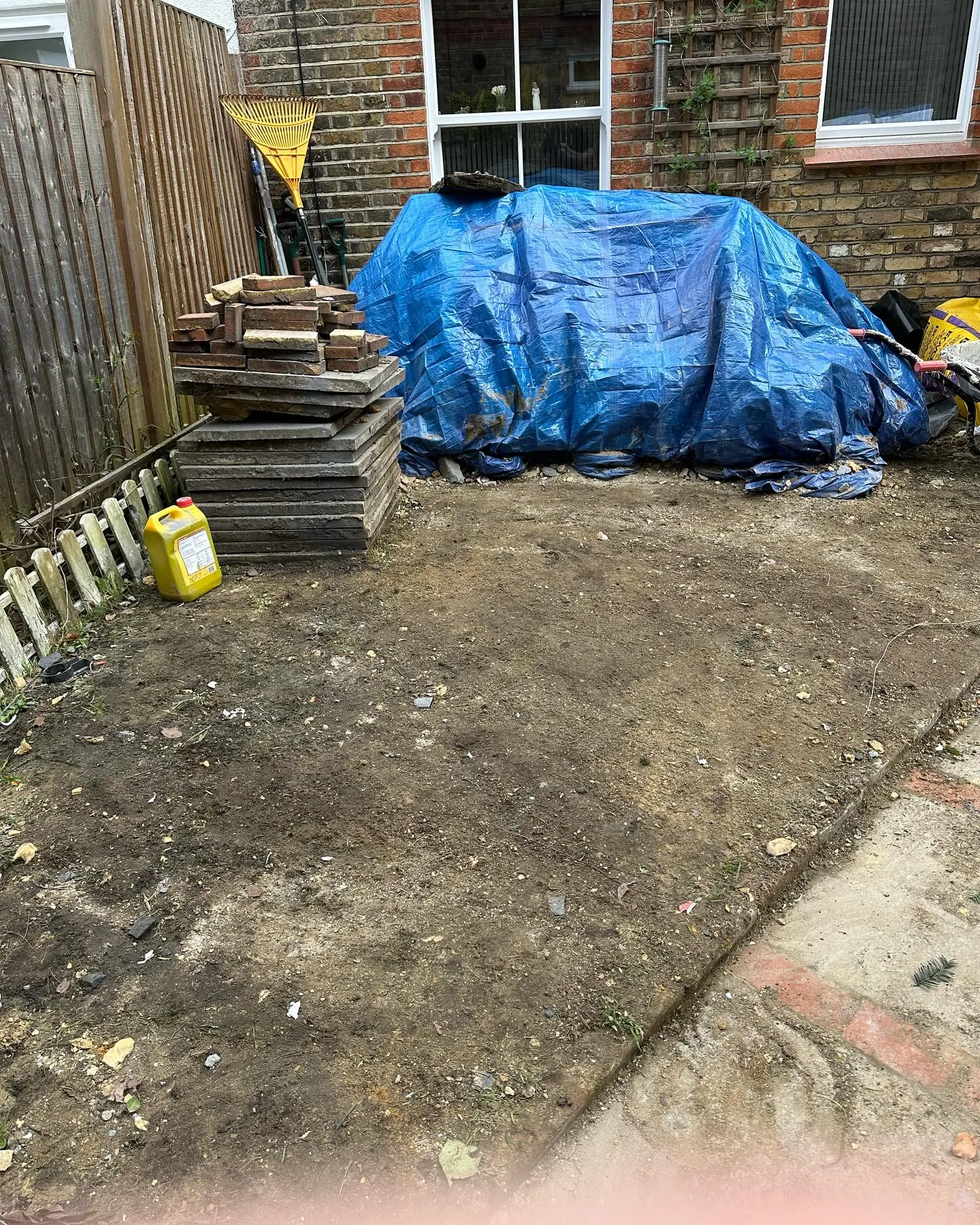 A yard with a blue tarp over it.