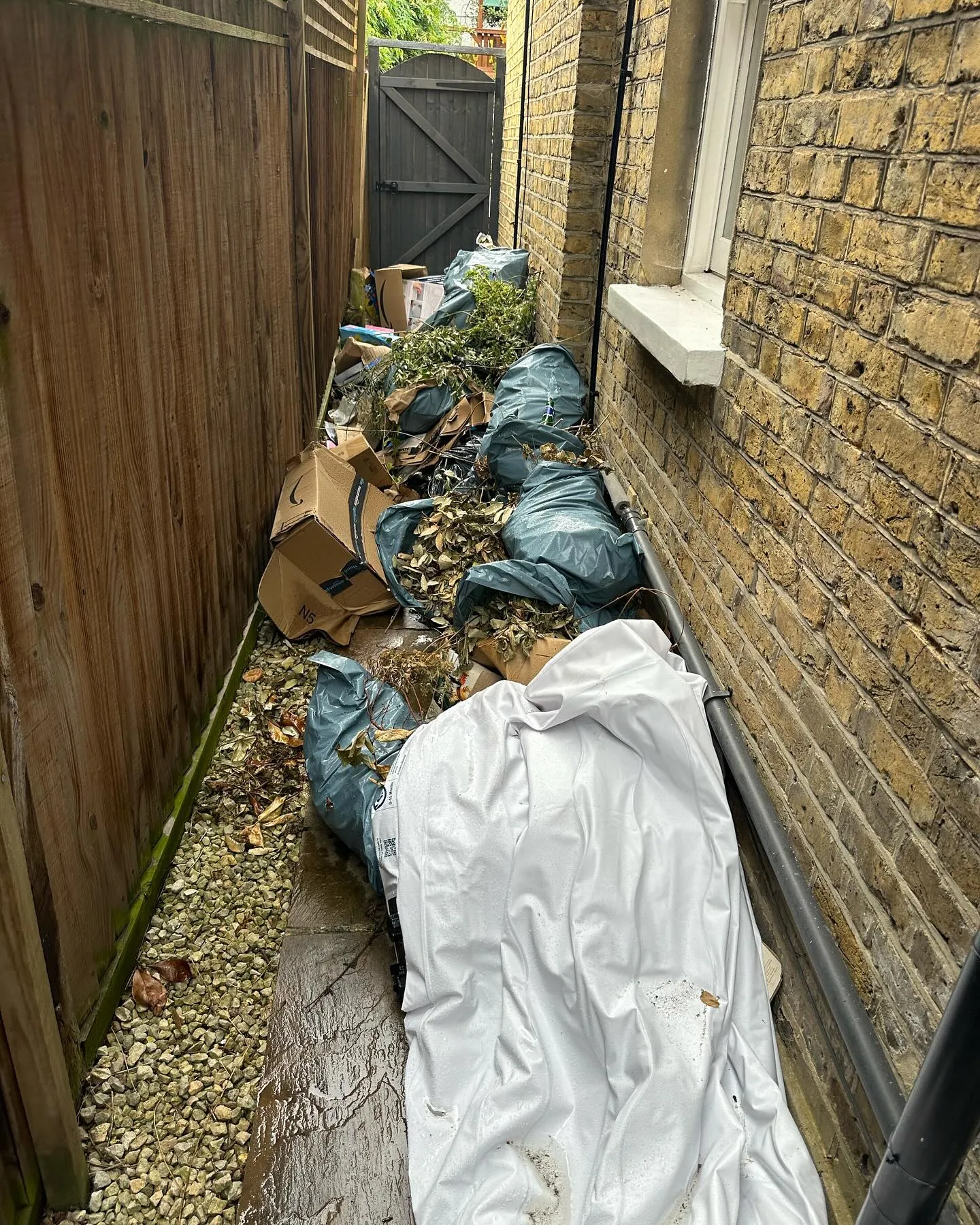 A pile of garbage sitting on the side of a building.