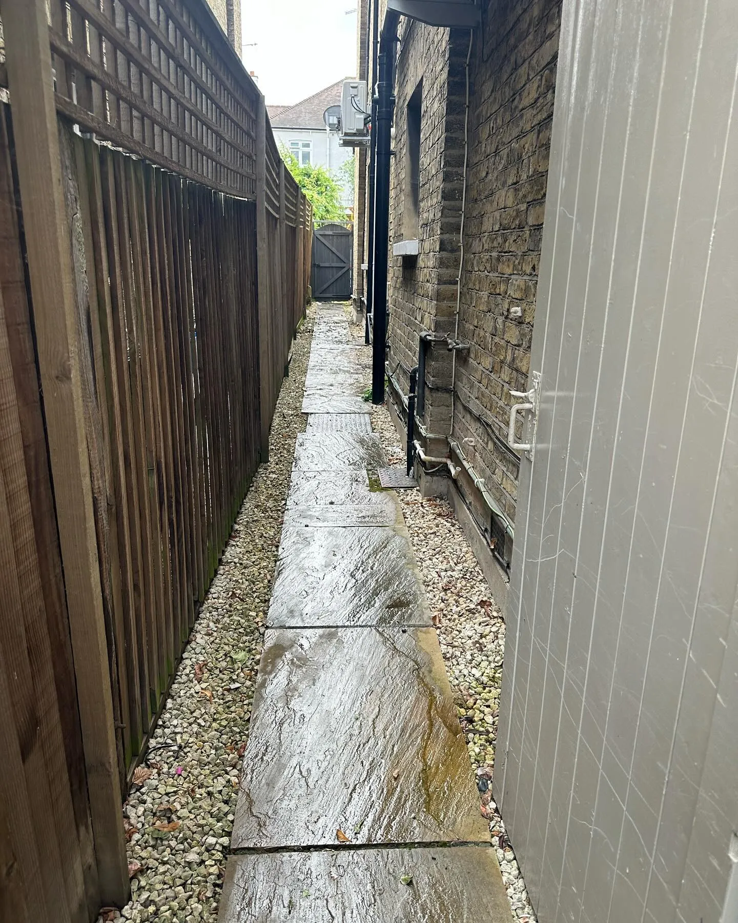A narrow alley way with a wooden fence.