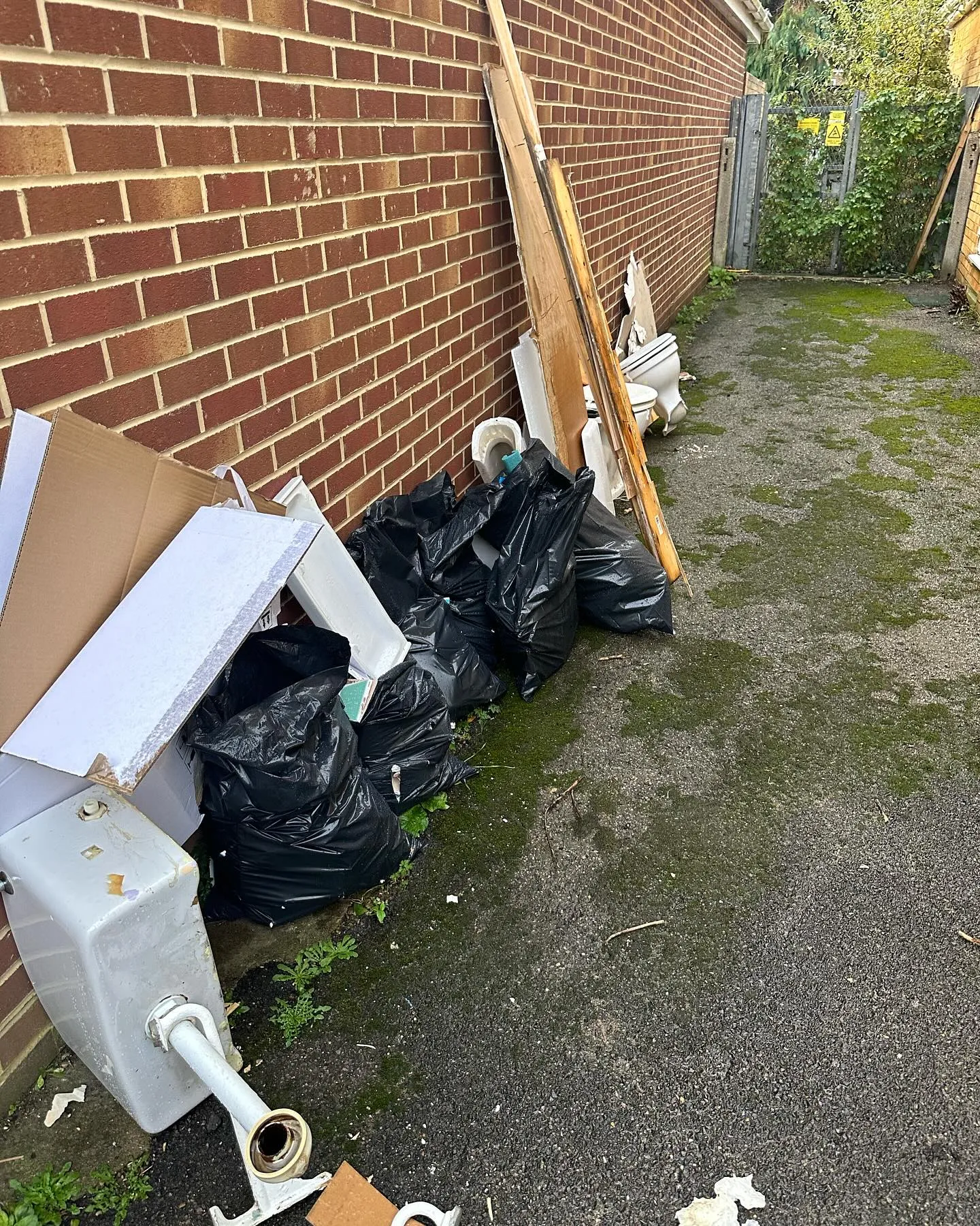 A pile of trash sitting next to a brick building.