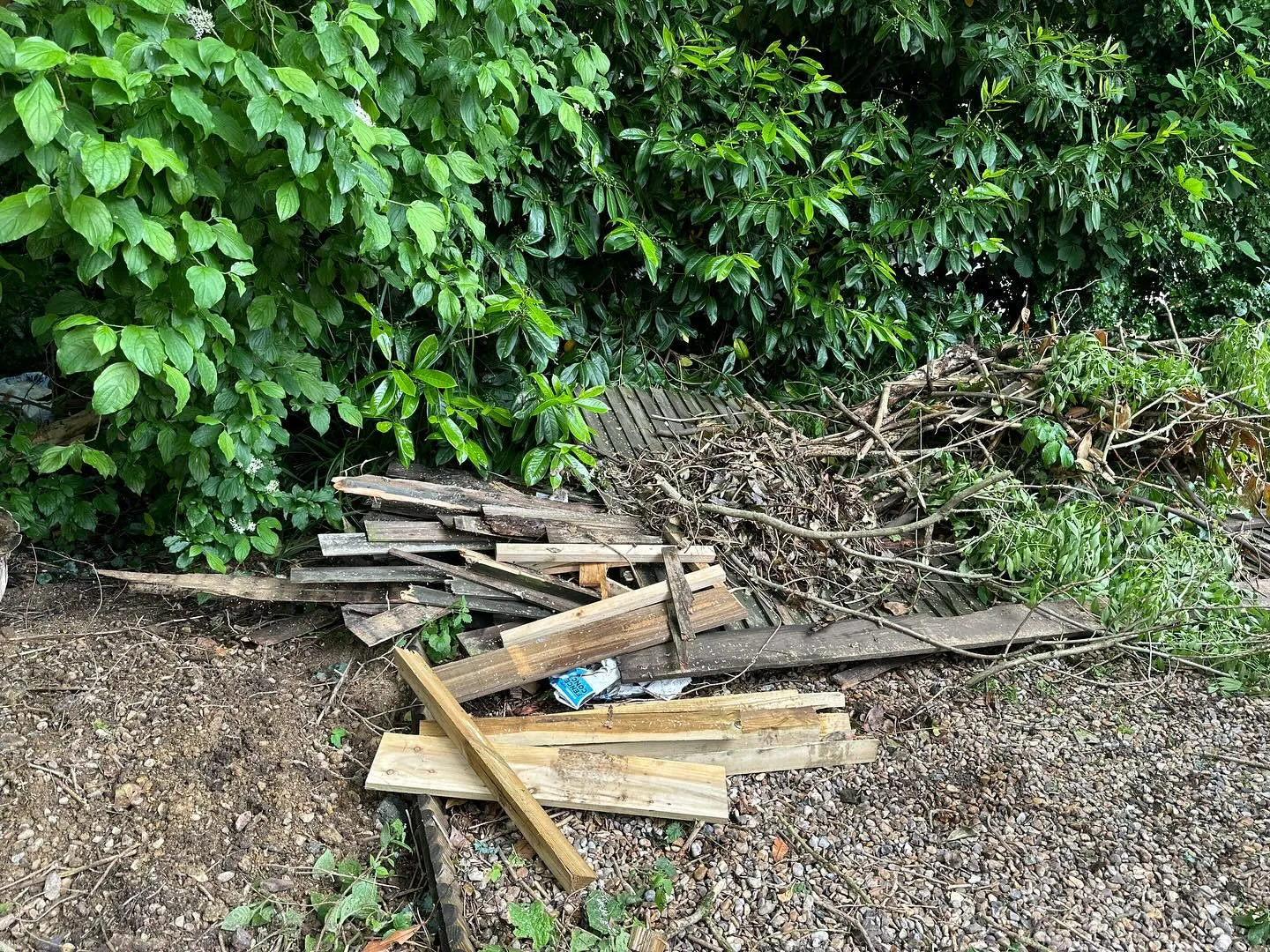 A pile of wood sitting on top of a dirt field.